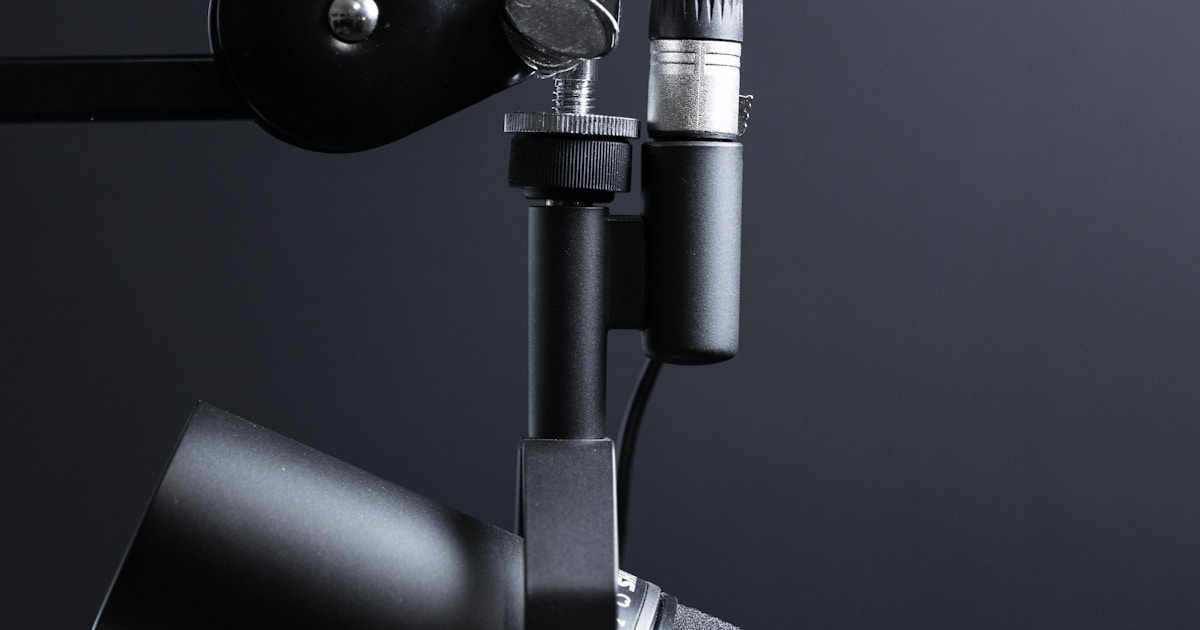 Close-up of a person speaking into a headset microphone in a bright workspace